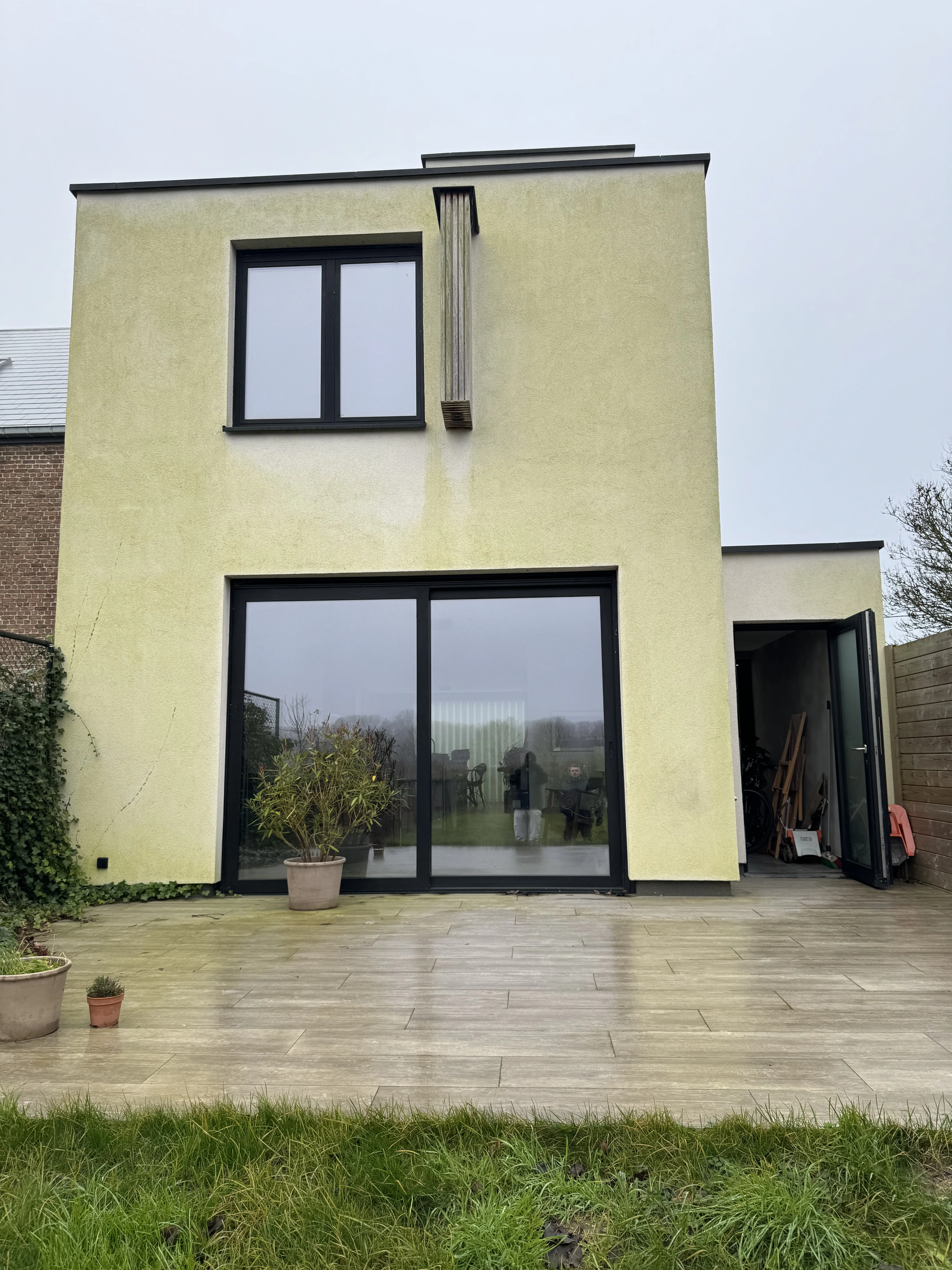 Witte crepi gevel voor Crepi Care reiniging — groene aanslag